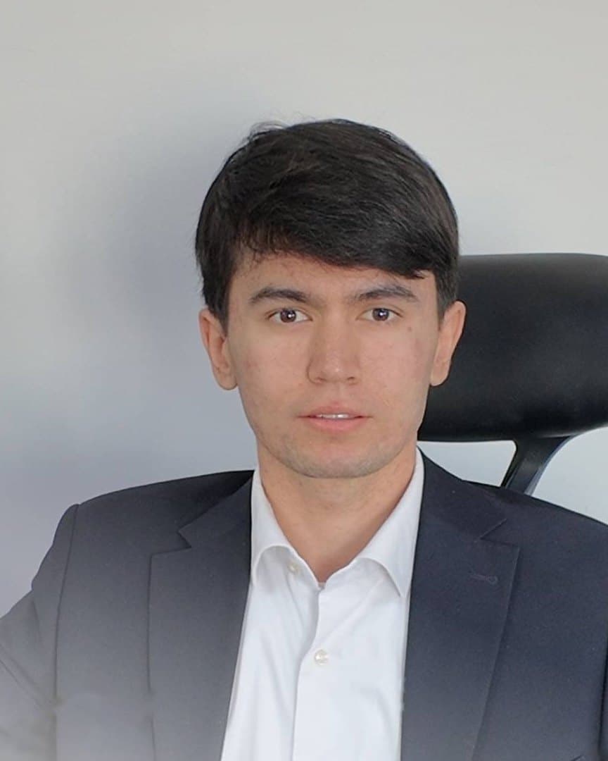 Shahriyor Rahmatov, con traje azul marino y camisa blanca
